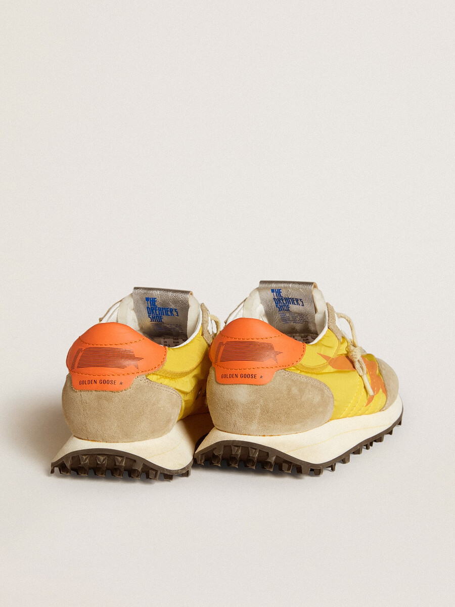 maratón para mujer con parte superior de nailon amarillo y estrella naranja